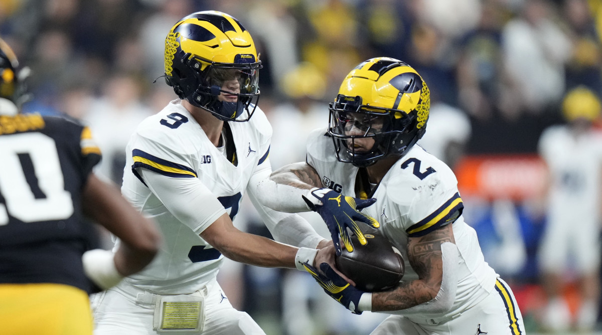 Michigan quarterback J.J. McCarthy, left, hands the ball off to running back Blake Corum.